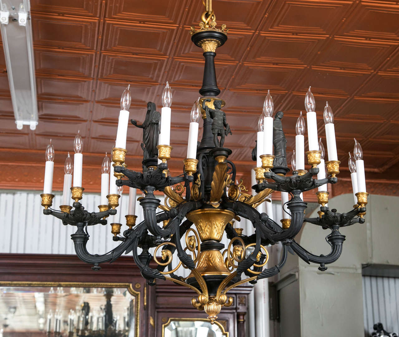 A rare and unusual two tone bronze chandelier. This chandelier was originally gas and has been converted for electricity. The six bronze Greco Roman figures are surrounded by thirty lights. The quality of the casting is quite nice.