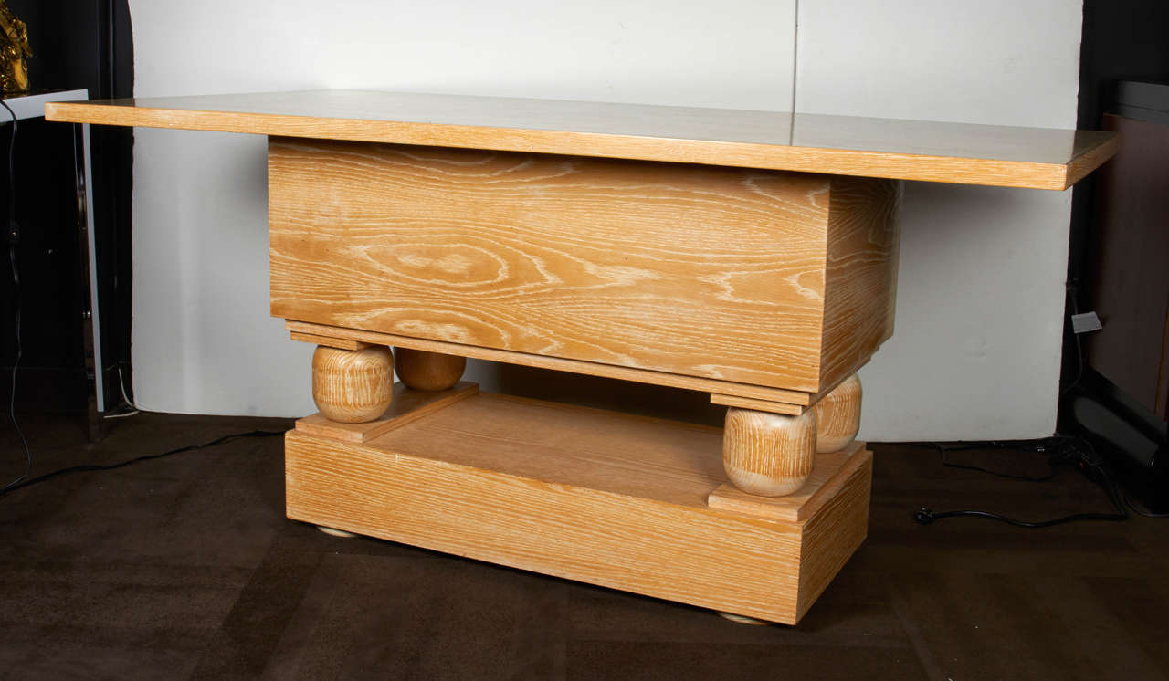 Custom commissioned center table or console table after Paul Dupré-Lafon. Large dimension and heavyset structure comprised of limed oakwood. The gorgeous table features a rectangular base with plank wood details and four turned wood pedestal orbs.