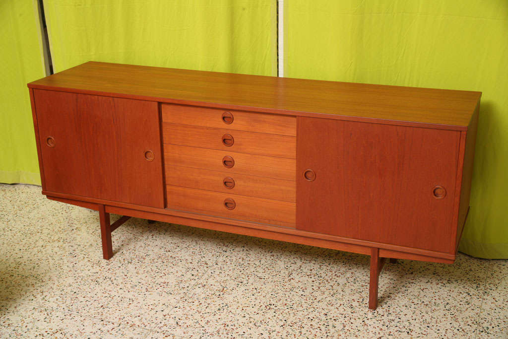 SOLD AUG 2010 Swedish Modern rocks!  This Dux teak sideboard credenza features five centered drawers, the top drawer felt lined and partioned.  On either side of the drawers are shelves with sliding doors.  The interiors are lined with birch.  Just