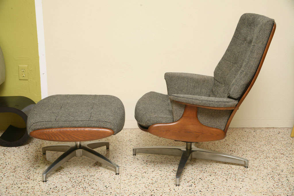 SOLD AUG 2010 A fine take on the Eames 670 lounge chair in beautifully shaped solid walnut featuring a high back modern Windsor style back supports and tufted tweed upholstered cushions and matching ottoman both with swiveling polished aluminum star