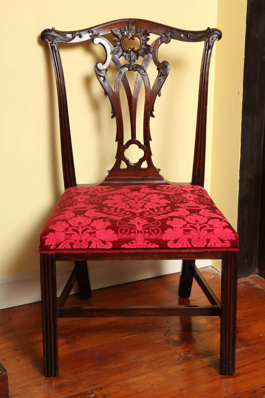 Very fine set of four antique Chippendale period mahogany side chairs with exquisite leaf carved top rails and carved and pierced splats and having a drop in slip seat above a show wood apron and four chamfered moulded legs with an 