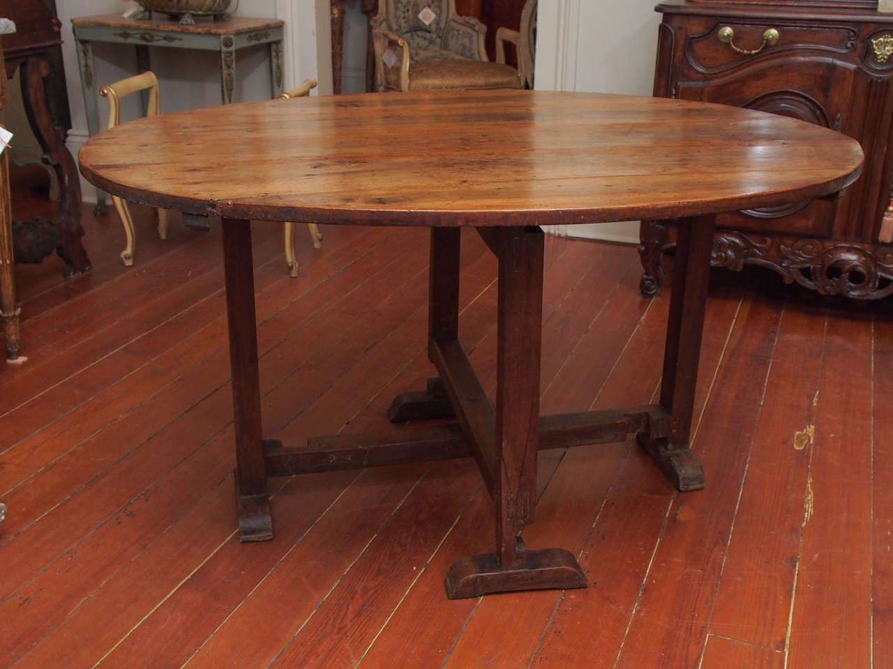 This tilt top table is notable for its commodious size (most tilt top wine tasting tables being much smaller), the oval shape of its top, and its handsome bracket feet.  Constructed of walnut, which has aged to a rich color and vibrant patina.