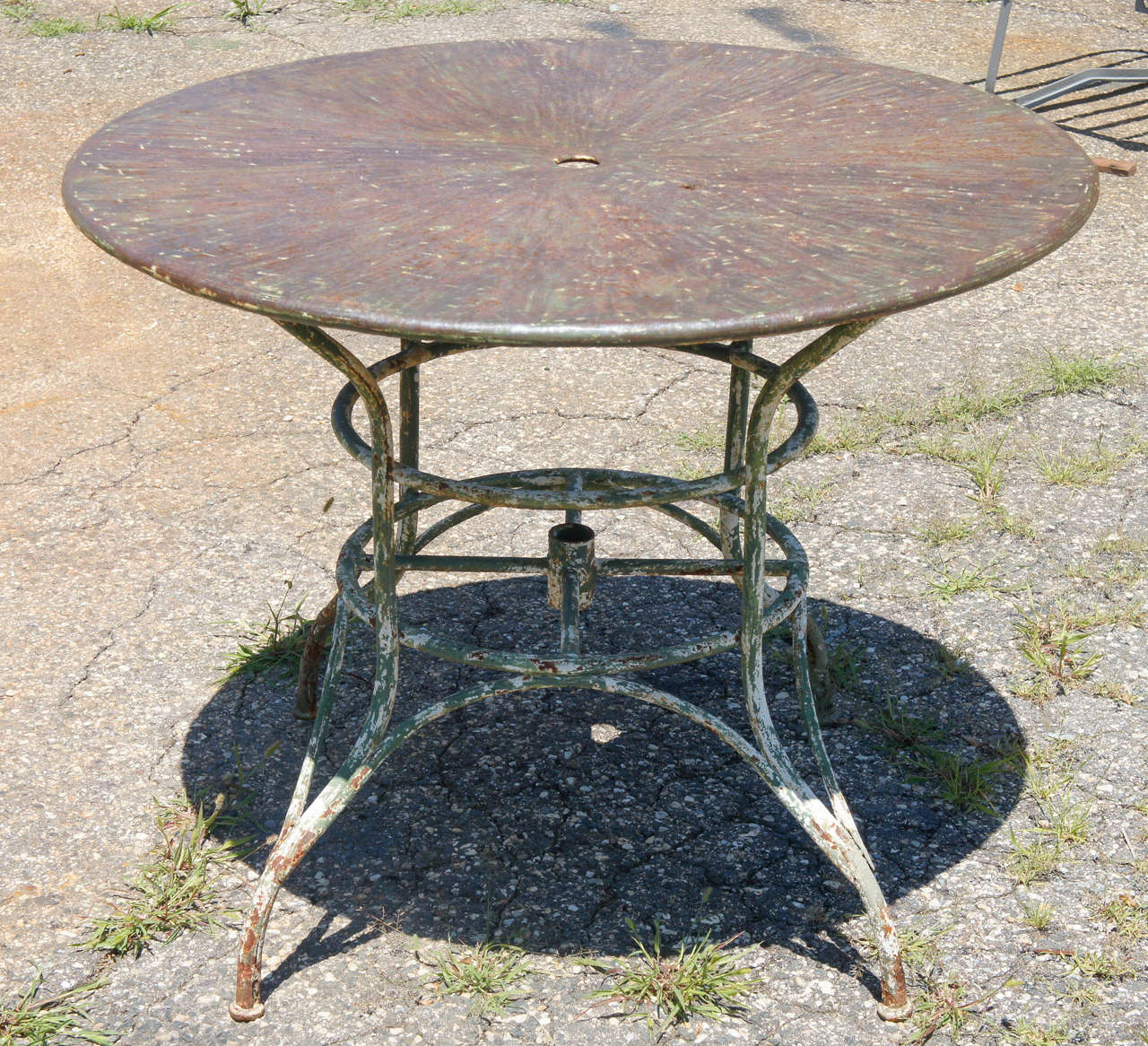 An unique indoor or outdoor round metal garden umbrella table with surface of colors splayed from the center.  This garden or patio table of steel is made to hold an umbrella with a hole in the center and tubing attached to the leg frame.

Base: 
