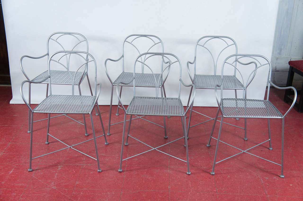 The six Art Deco chairs that once stood in a Parisian park or bistro garden chairs can now grace your porch or terrace -- they have been newly painted silver.  The seats are made of metal screening.  Cross bracing secure the legs.  

Arm height,