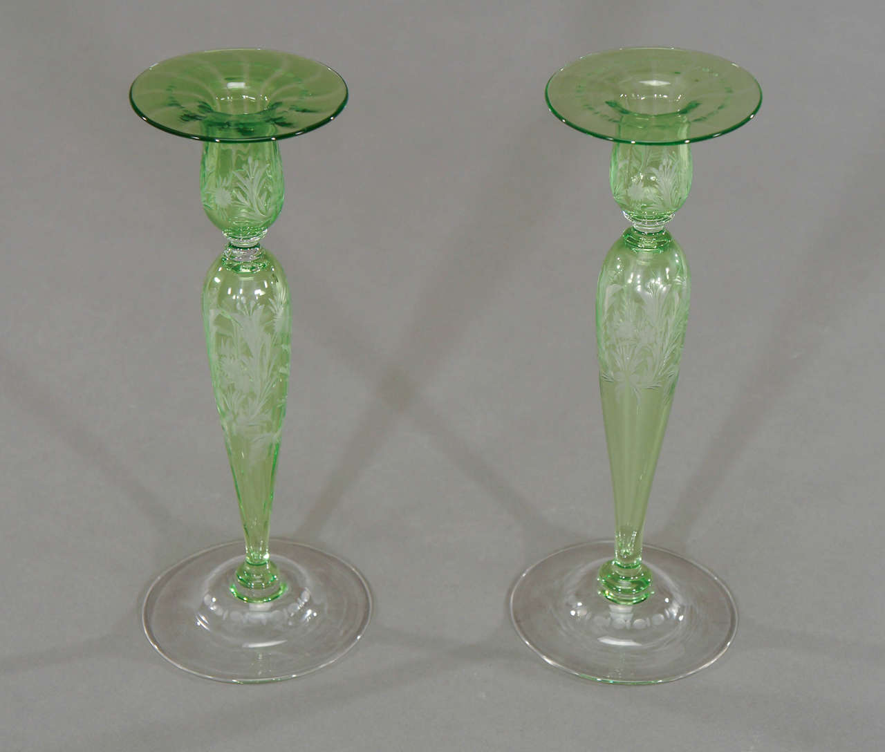 This pair of candlesticks are outstanding examples of Steuben's finest glassblowing and workmanship.
 Hand blown crystal with "Pomona Green" overlay and cut to clear in a clean Art Nouveau stylized floral pattern with subtle optic ribbing