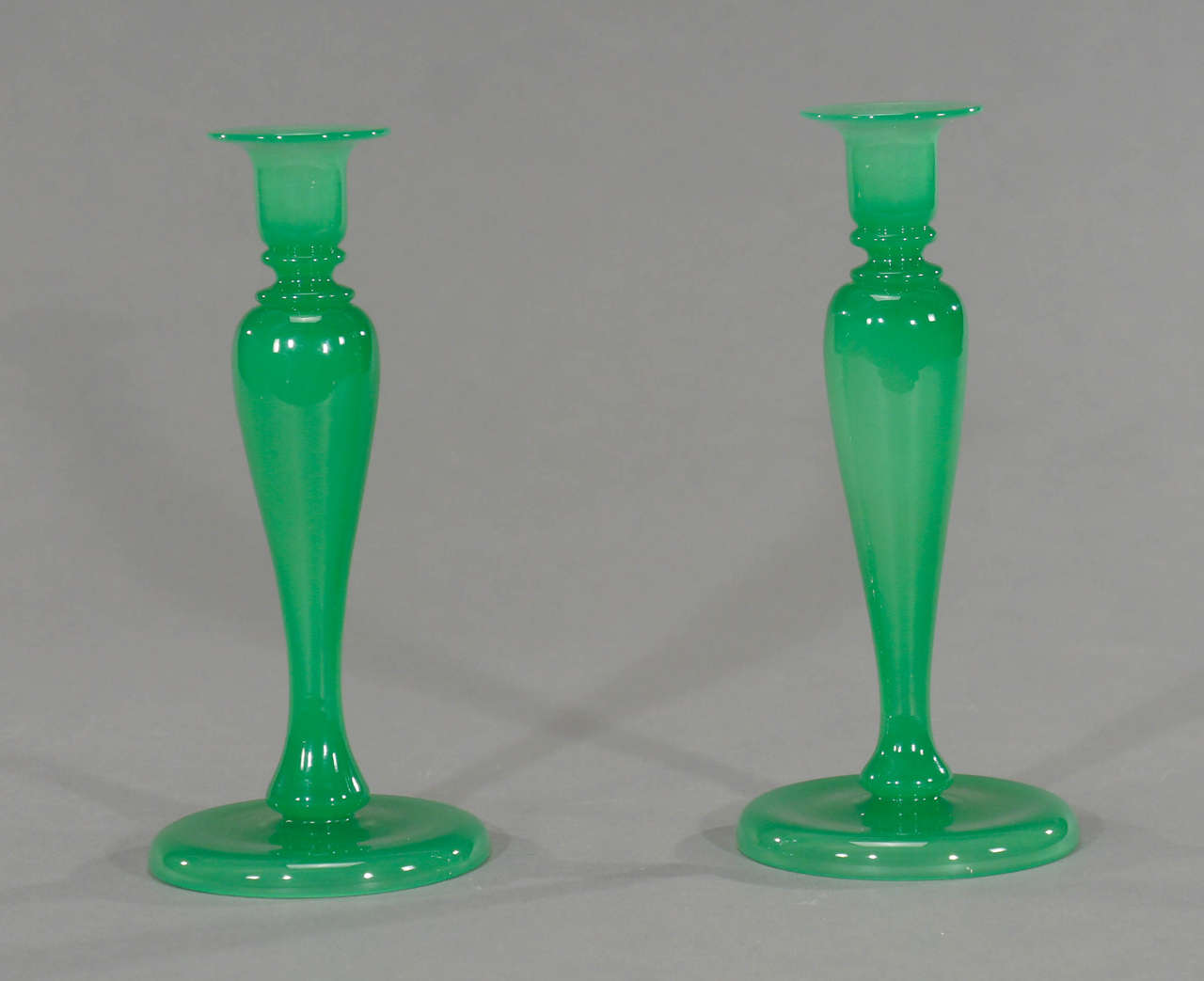This wonderful pair of hand blown candlesticks was made by Stevens and Williams or Steuben in the transitional period while Frederick Carder was moving to Corning Glass Works to become the new director. The color is rich and deep and looks to be a
