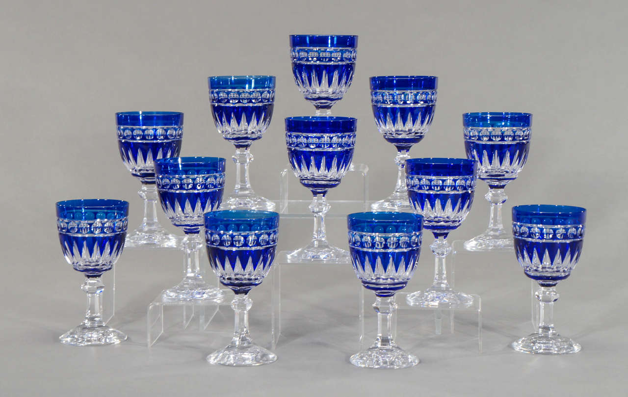 A magnificent set of twelve hand blown crystal goblets, cobalt overlay, cut to clear in a classic, clean pattern that works in any decorative period. Art Deco, Mid-Century Modern and most importantly, a hard to find cobalt blue.These create a