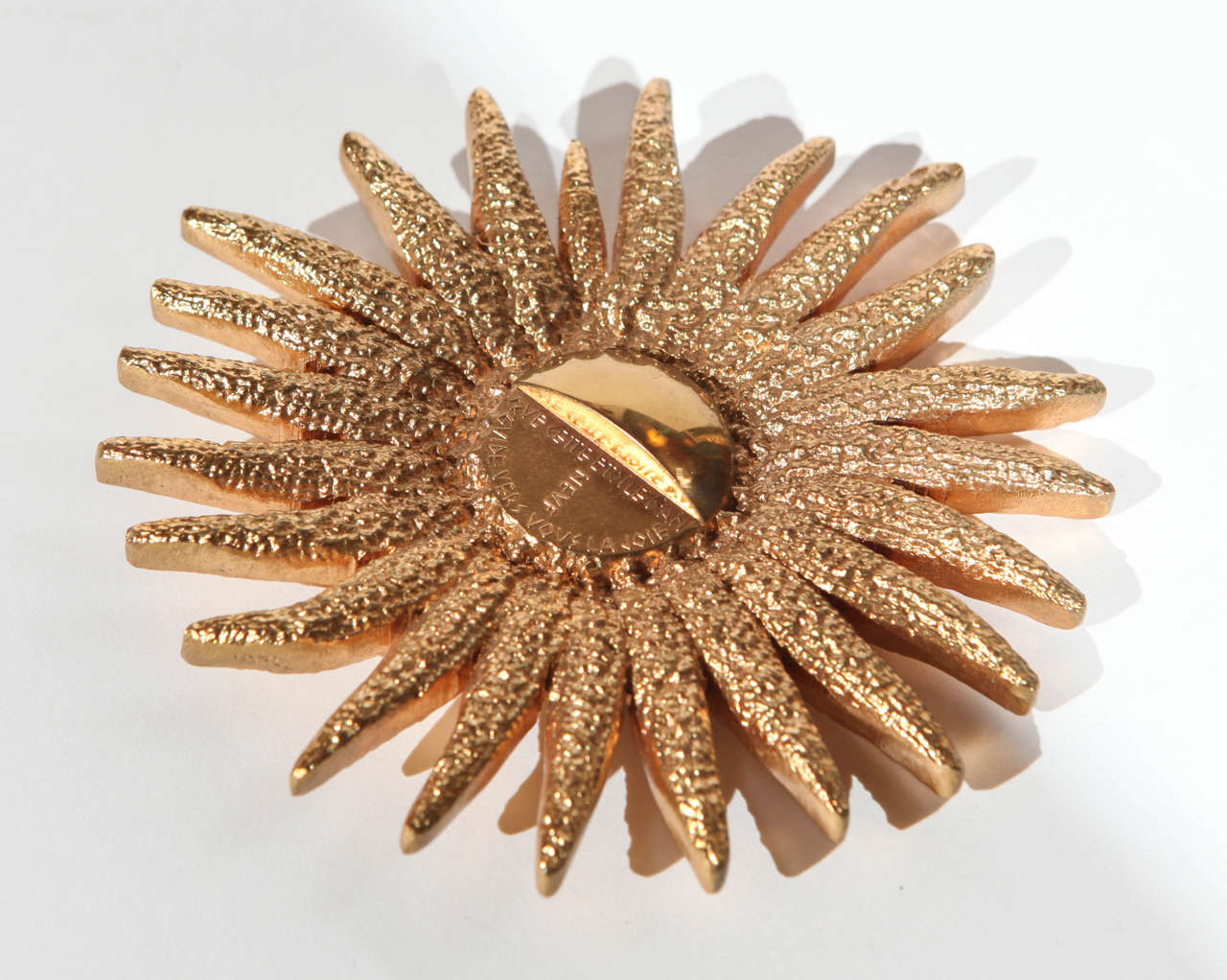 An amazing gilded bronze starburst paperweight in the style of Line Vautrin. Center section is inscribed 