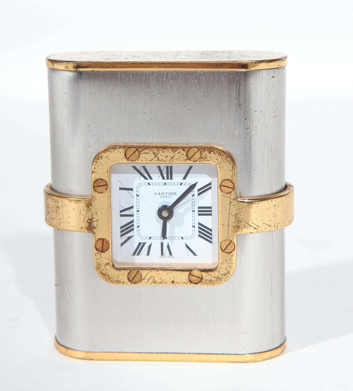 A vintage French Cartier clock. Made of gold plated metal and brushed steel. Has French markings on the base. Note that there are some scratches and oxidation on the gold plating.