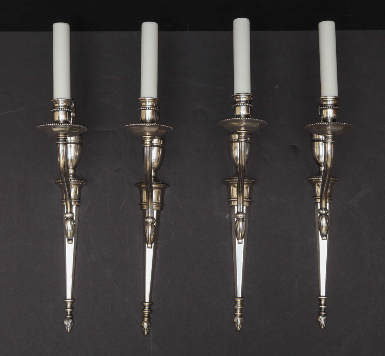 Set of Four Silvered Bronze Louis XVI Style One Light Sconces With Urn And Flame Motif.