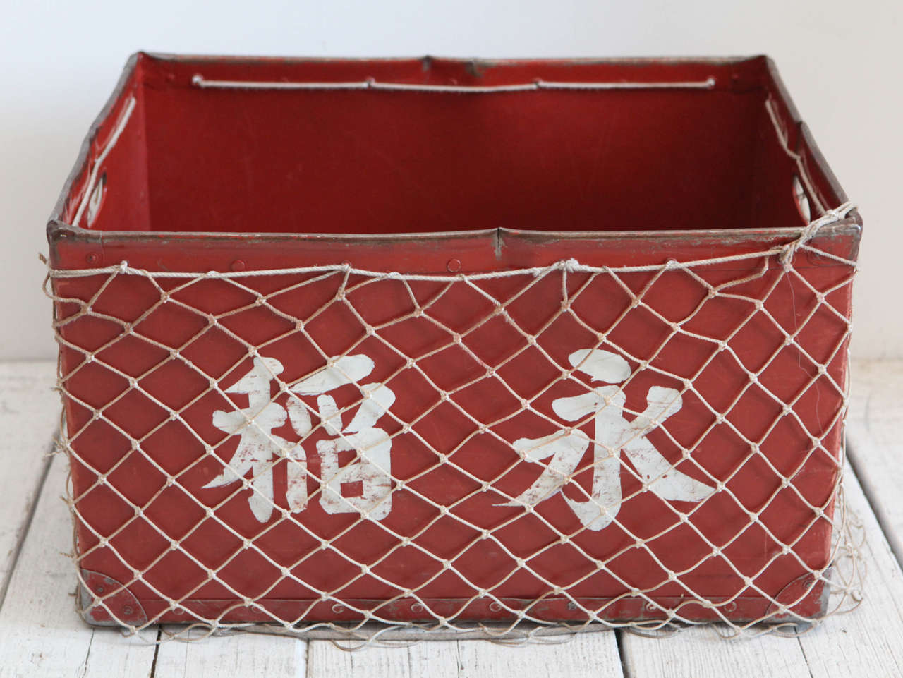 Tin crate with hand knotted fish net or rope for various storage uses.