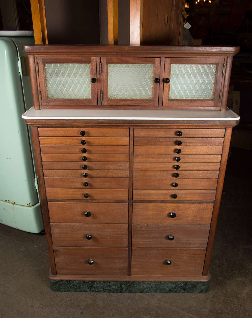 1920s three-door wooden cabinet with original matching black pulls, textured glass, numerous drawers and six larger storage drawers near the bottom. This can be seen at our 1800 South Grand Ave location in Downtown Los Angeles.
