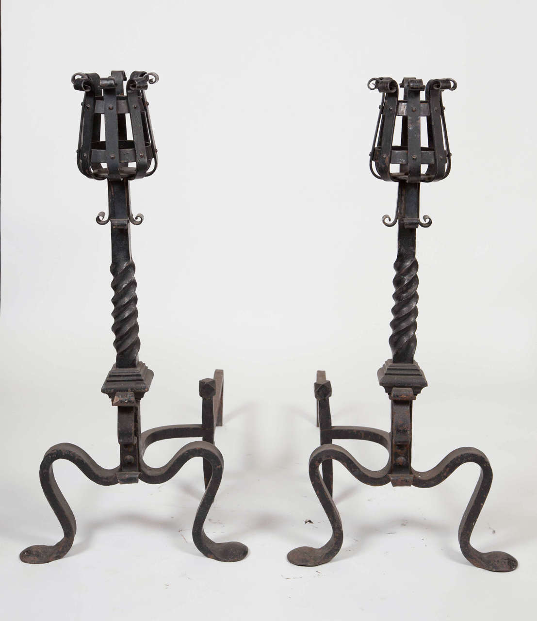1890s pair of twisted and riveted wrought iron andirons with mug holder tops. These can be seen at our 1800 South Grand Ave location in Downtown Los Angeles.