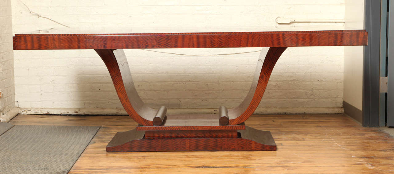 Elegant Art Deco dining table in Cuban flame mahogany. It has two table cloth extensions 20" ea. bringing the total length when opened to 119".