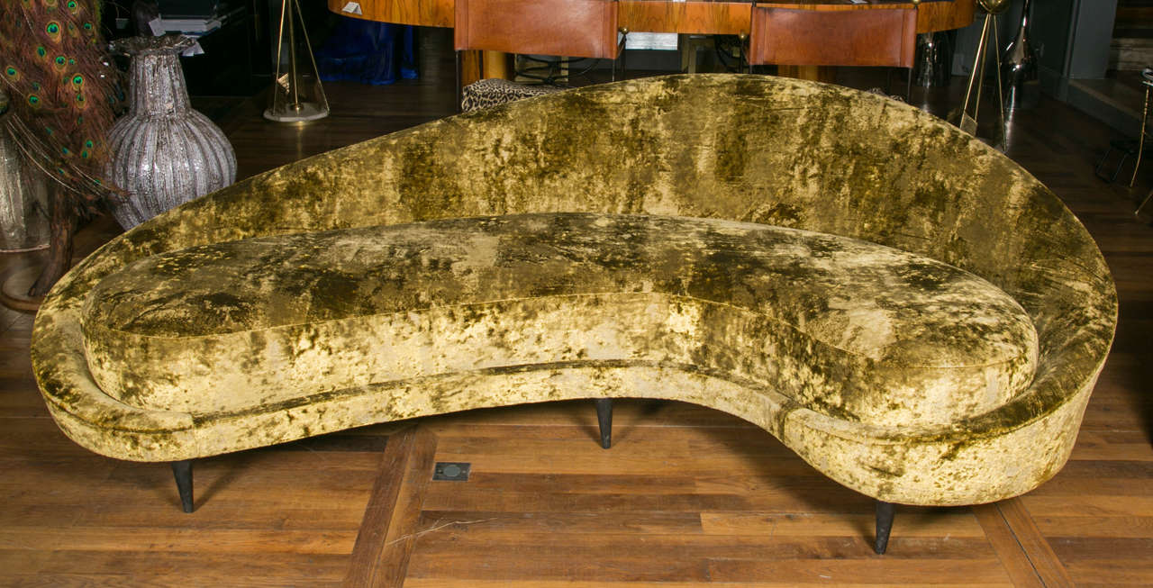 Vintage sofa, totally upholstered with gold velvet, seven wood feet.