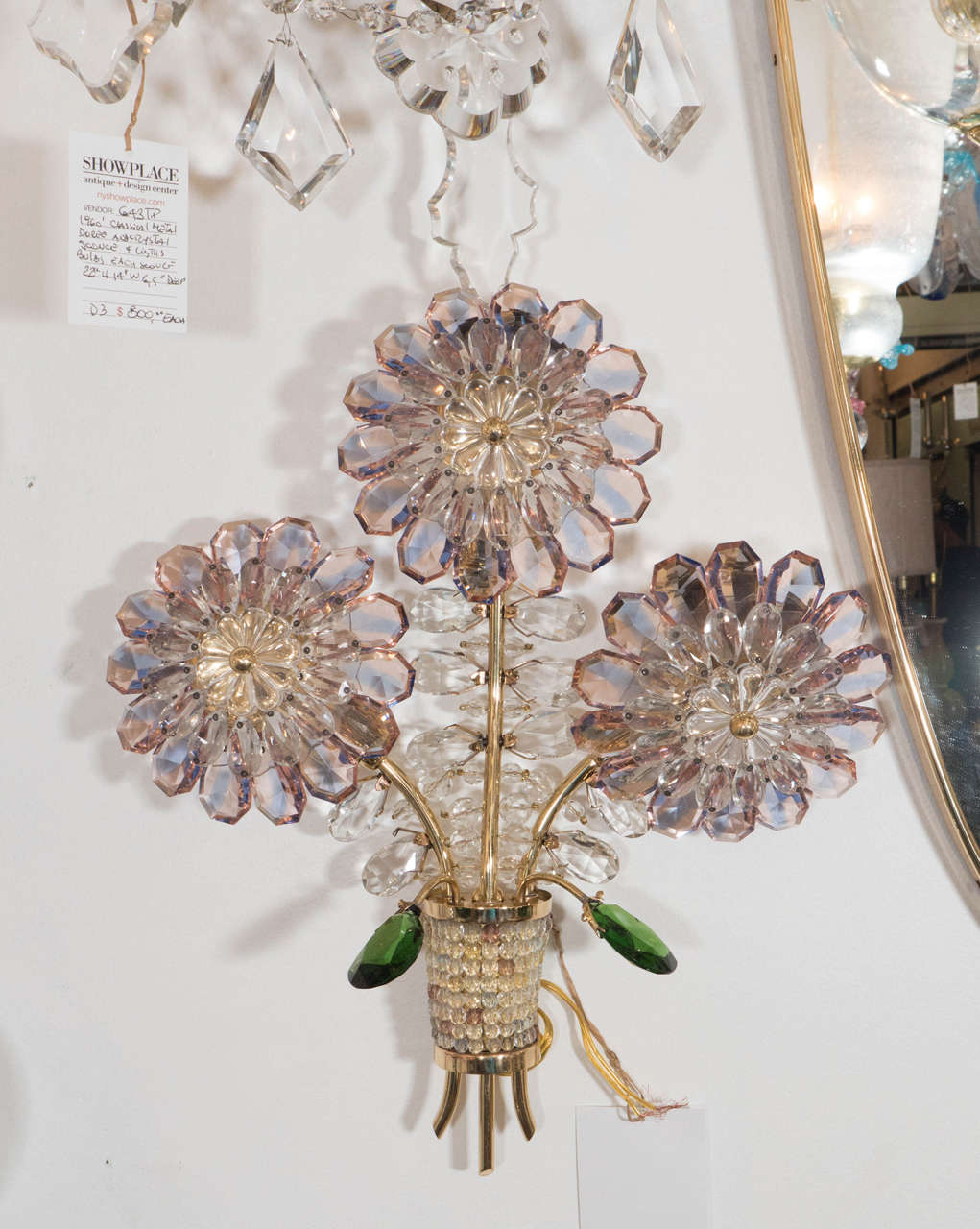An incredible and unique pair of 1950s Italian crystal flower and brass sconces. Each crystal petal is pale coral or salmon in colour with a central lavender stripe. Green crystal leaves flank the bouquet stems
Behind the crystal flower is a hidden