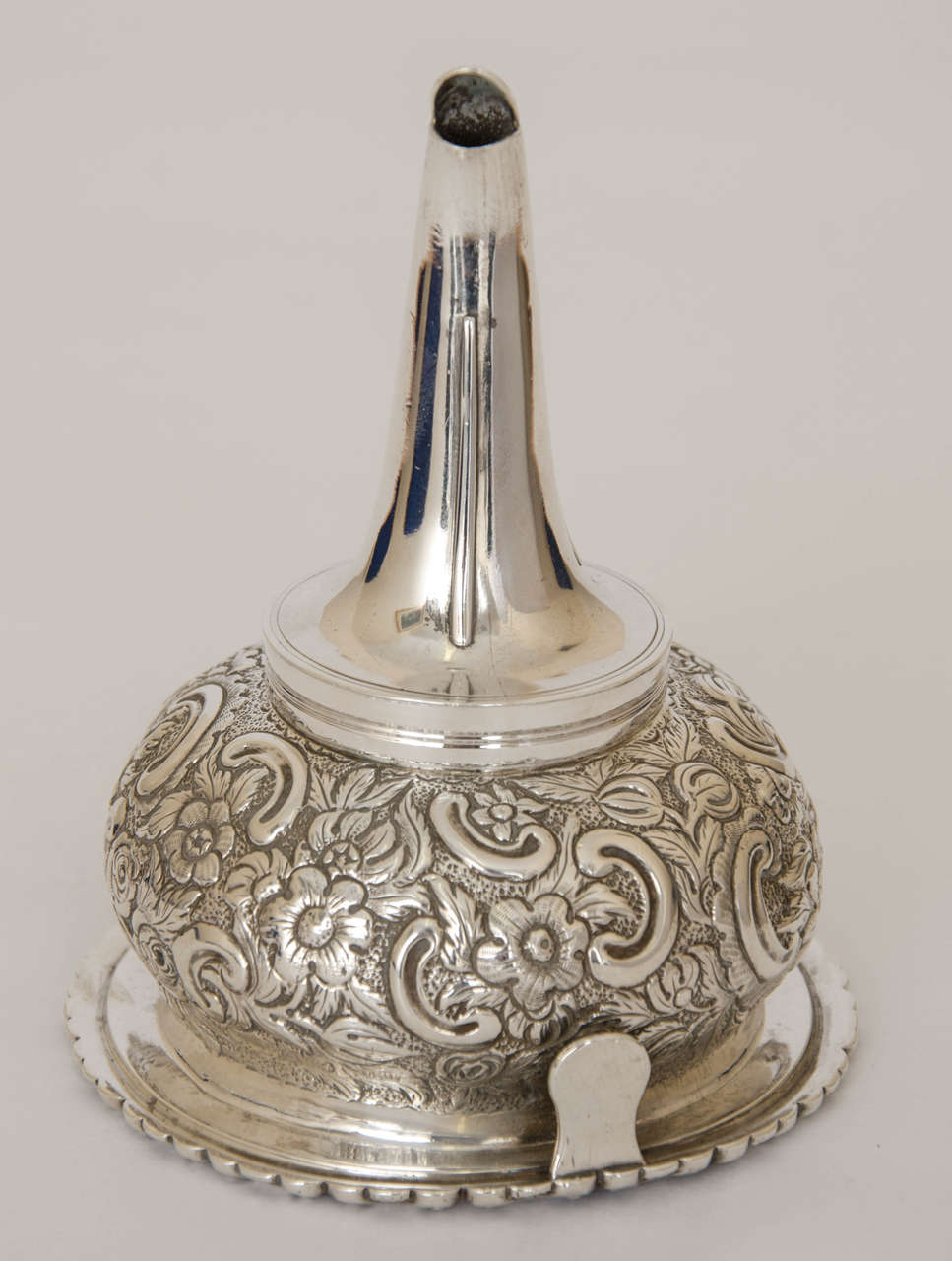 A very fine Antique Sterling George III Regency Period Wine Funnel; the bowl is beautifully embellished with flowering vines on a matted ground. To one side, within the design is a cartouche containing a family crest .The push fit hallmarked