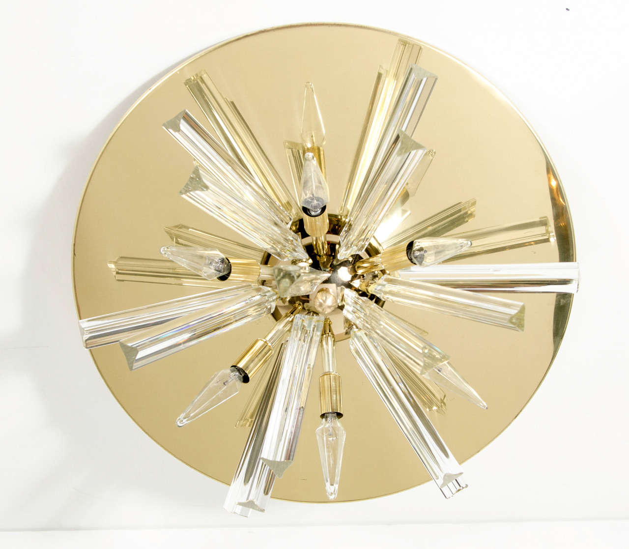 This stunning Mid-Century Modernist flush mount chandelier has Murano glass triedre crystals and lights emanating from a central dome on a polished brass base plate. A real eye catching piece, bound to look fantastic where ever it is used!
Newly