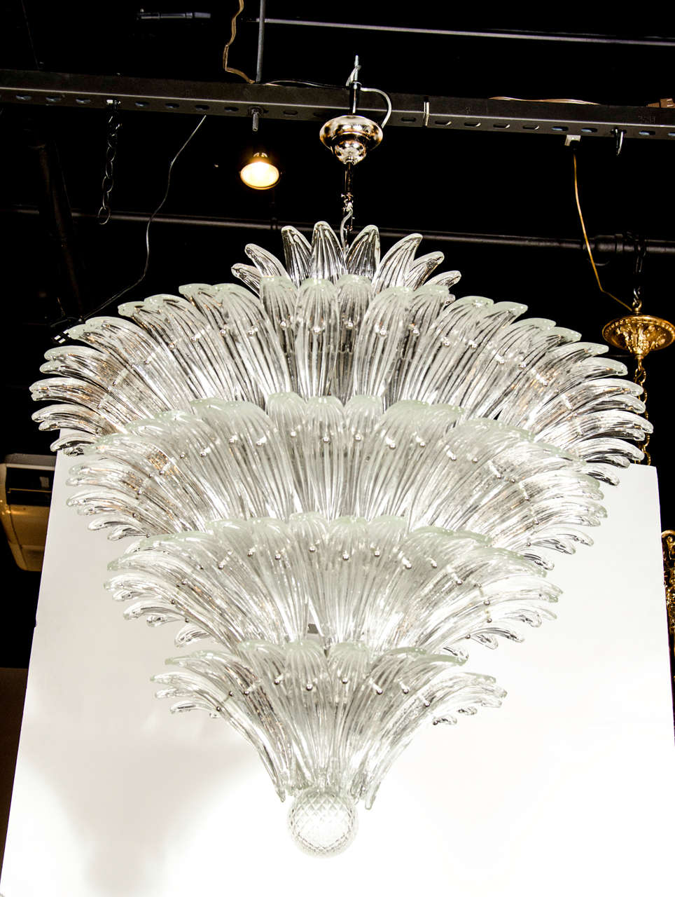 This exquisite “Palma” chandelier was realized in Murano, Italy- the island off the coast of Venice renowned for centuries for its superlative glass production. It consists of five tiers of handblown translucent Murano glass in the form of stylized
