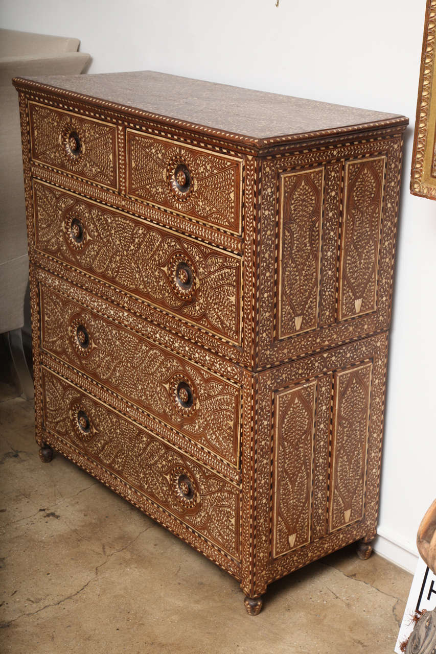 A tall wood chest with five drawers.  Bone inlays in a classic pattern throughout, from India.