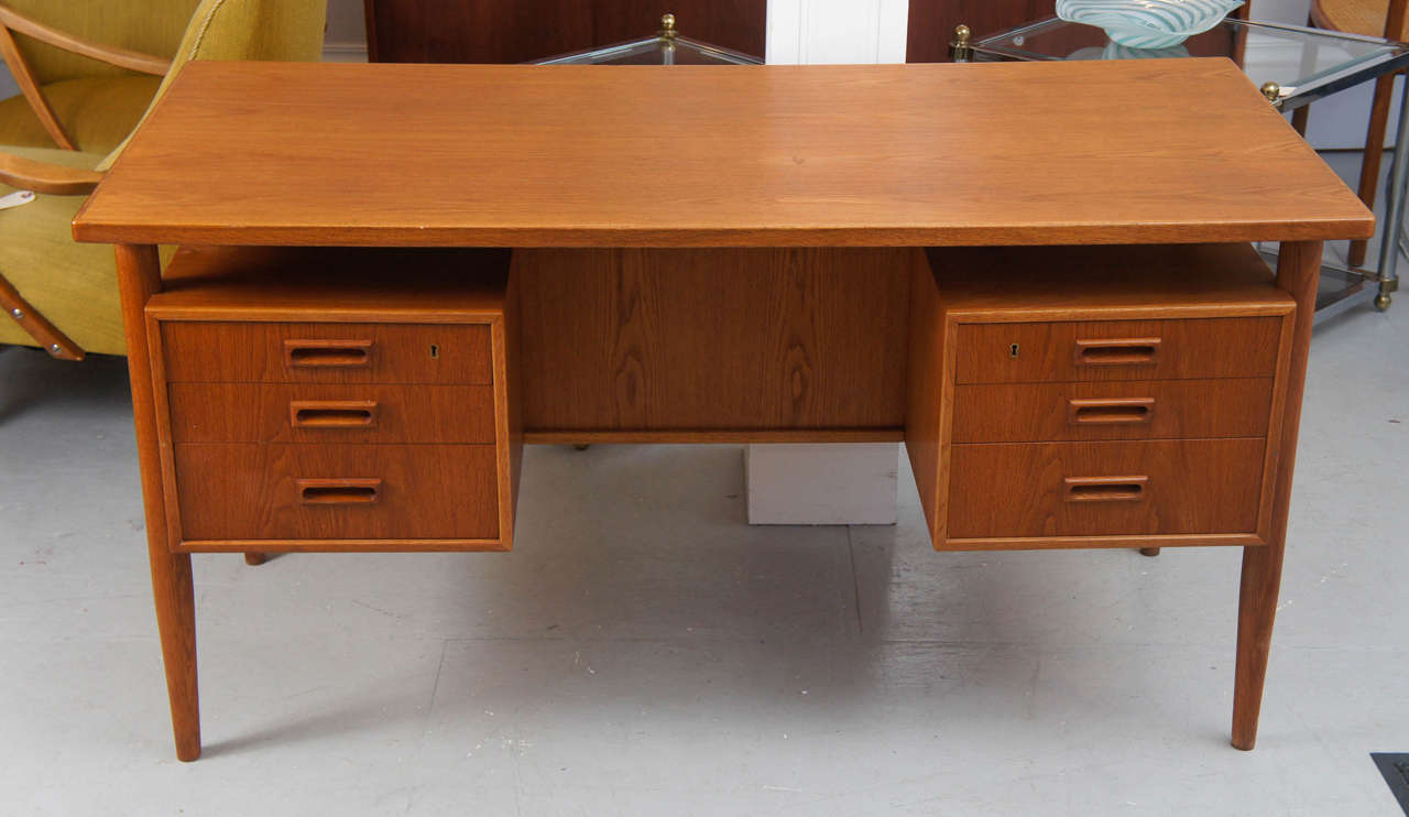 A good looking Danish Desk that is finished on all sides, with open storage on the back side.