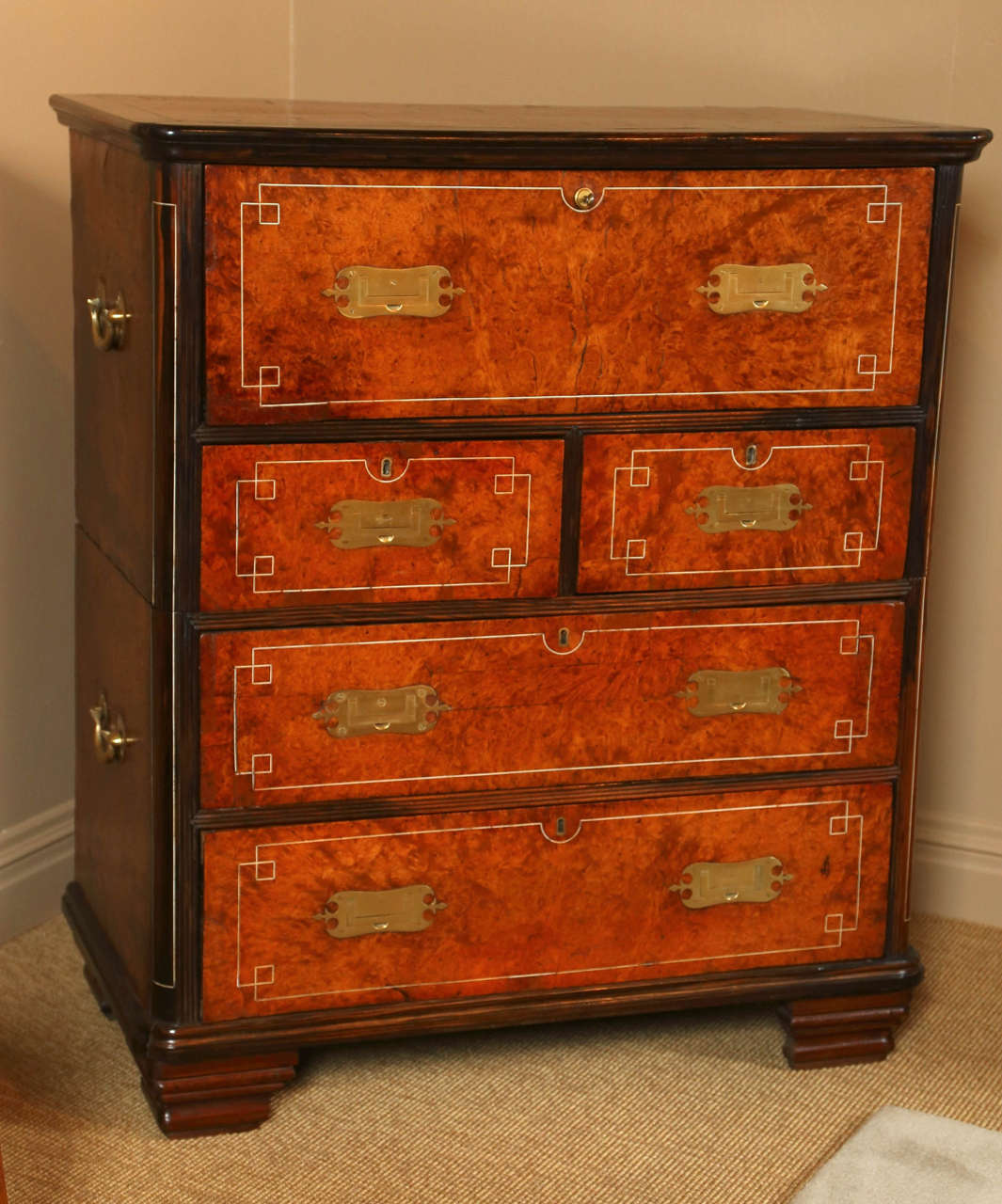 A campaign chest of rosewood and burl veneer with bone inlay decoration and having secretaire top drawer with tooled leather writing surface.  Original brasses, handles and key.  Southern India, circa 1880 - 1890.