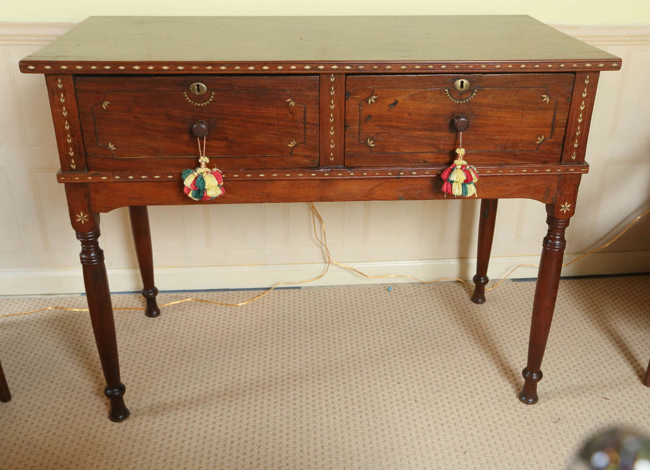 A good size Anglo-Indian teak wood, two drawer Provincial server or console or buffet on turned legs decorated with inlay work of various geometric forms.  The full facia drawers with original knobs & locks surmounted by an inlaid demilune