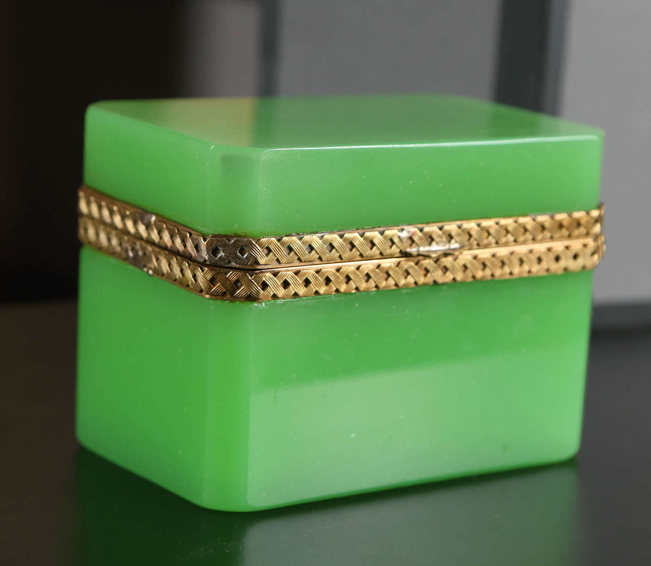 An opaline green glass box with braided bronze mounts.