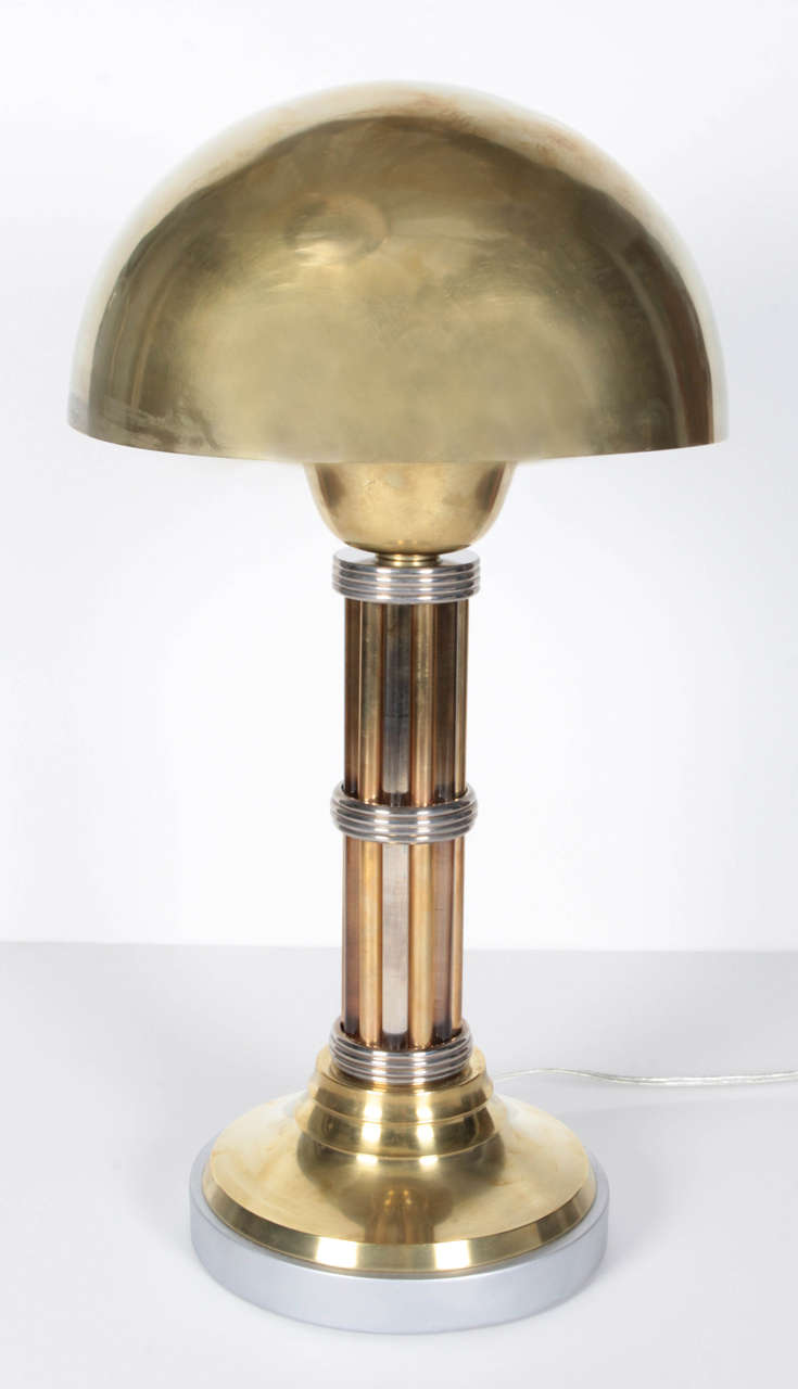French Art Deco brass, nickel, and glass dome shaped lamp-
A  deep, spun brass demi-sphere rests atop an unusual alternating brass and glass rod column intersected by three nickeled bronze rings, and mounted on a stepped base ending in silvered