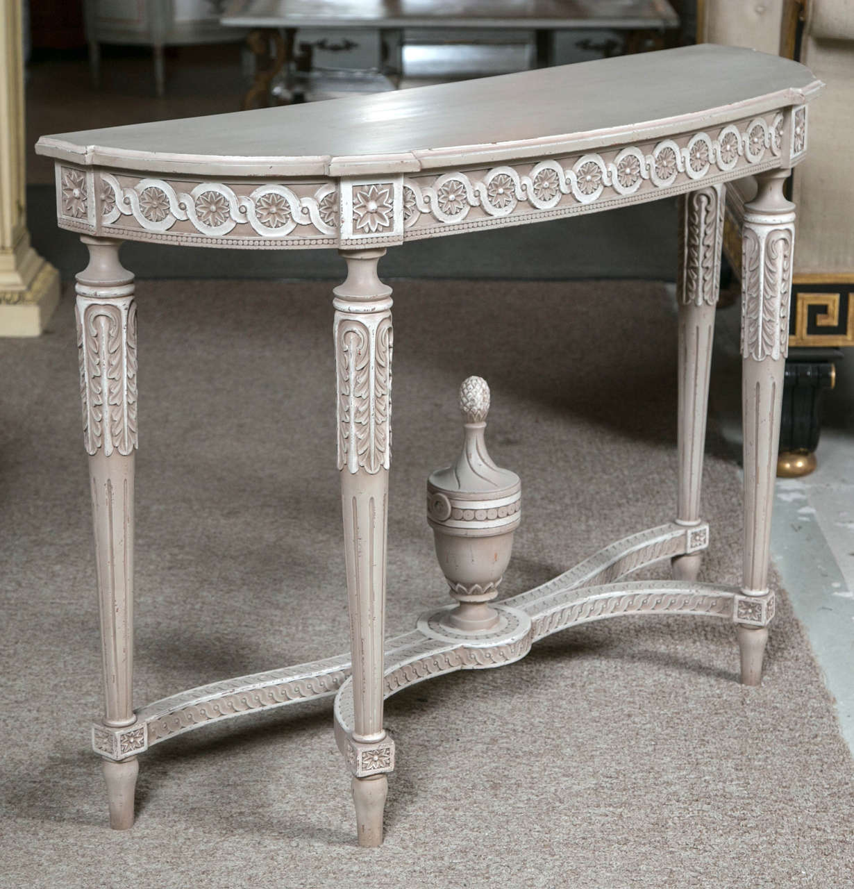 A charming French polychromed demilune console table in the style of Louis XVI, circa 1940s, distress-painted in grey/off-white, the half-moon shaped top supported on a narrow frieze decorated with patera and annulated carvings, raised on fluted