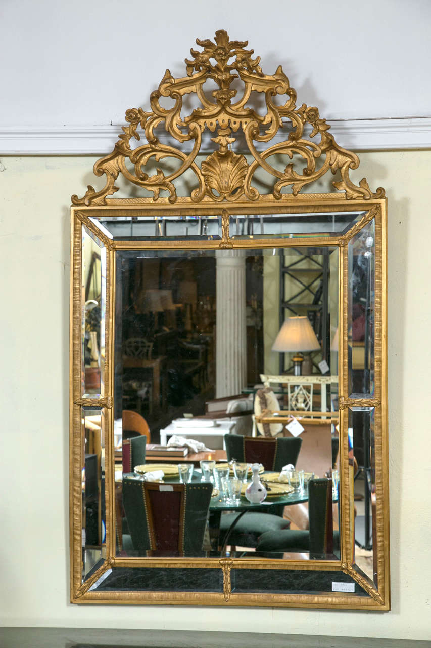 Italian palatial gilt wall or console mirror. A finely carved rectangular mirror. The center beveled glass mirror flanked by pairs of beveled glass mirrors in gilt wooden framing. The overall frame in ribbed form with wreath design leading to a