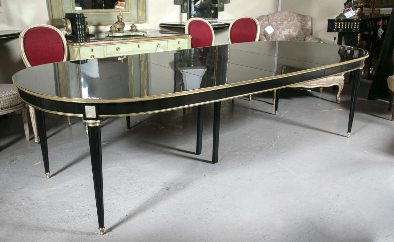 Louis XVI piano ebony finish dining table by Maison Jansen. Simply one of the finest Jansen dining tables on the market. This slightly over 12 feet dining table has recently been professionally redone with a Steinway piano ebony finish. The bronze