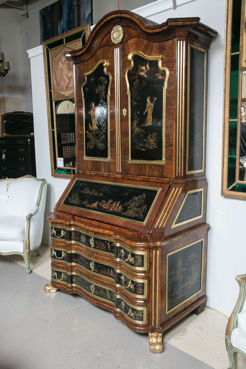 A spectacular one of a kind Continental walnut secretary bookcase in the chinoiserie taste, late 18th or early 19th century, the molded and domed cornice decorated by a bronze patera in the center, over a conforming case fitted with two cabinet