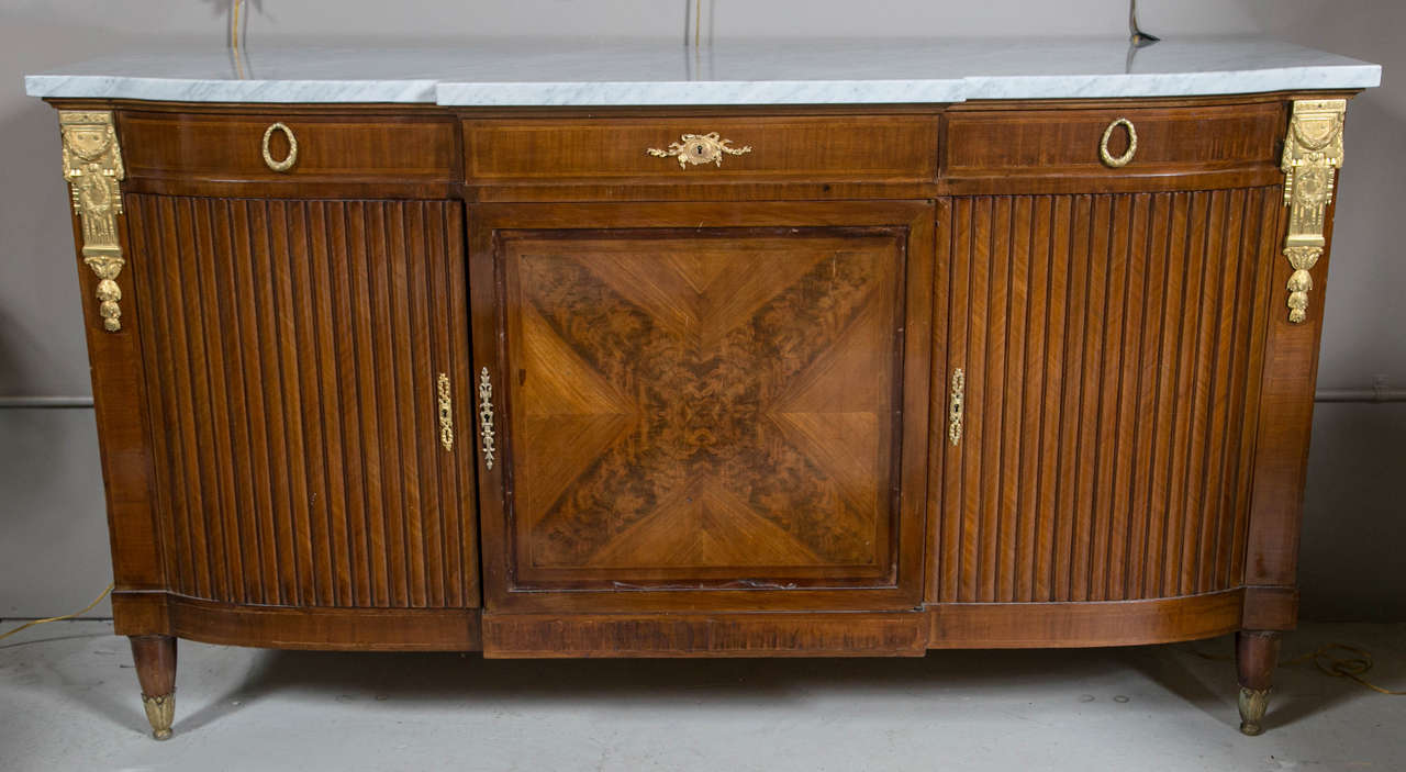 A Classic piece! French mahogany sideboard in the Louis XVI style, circa 1940s, the shaped white marble above a frieze fitted with three drawers.