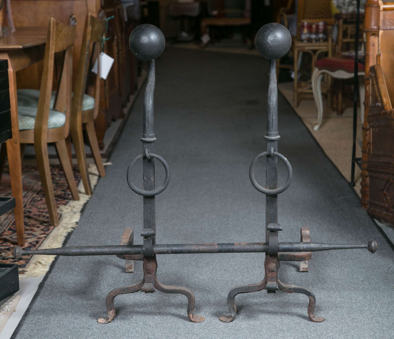 Pair of oversized iron andirons with large ball tops and iron crossbar measuring 39