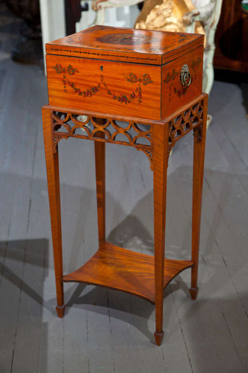 A  SATINWOOD, PAINT DECORATED  2 HANDLED  BOX  FROM THE EDWARDIAN PERIOD ON A NEWER  FRET WORK STAND WITH TAPERED LEGS. (NOT ATTACHED)