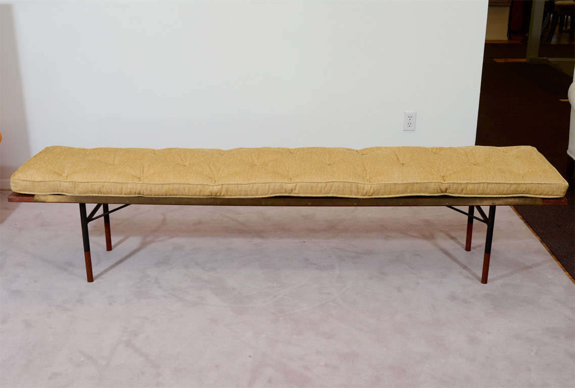 A vintage Danish Modern bench in teak and patinated metal with a gold-tone tufted cushion.