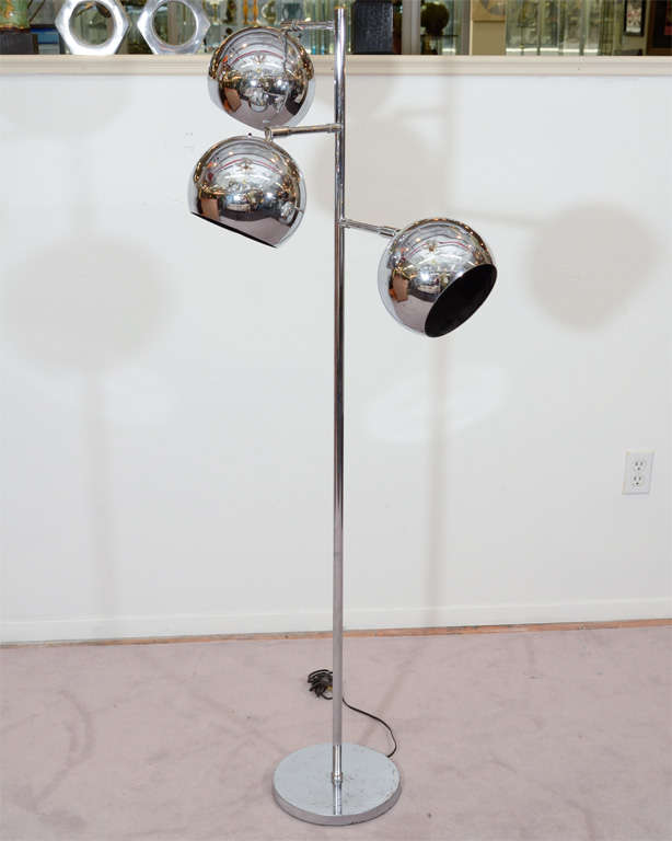 A vintage floor lamp, produced circa 1960's by Koch and Lowy, in chrome with three globe-form lights. Each light is hinged and pivots for a full range of motion. Very good condition, with age appropriate wear; some scratches and spotting to chrome.