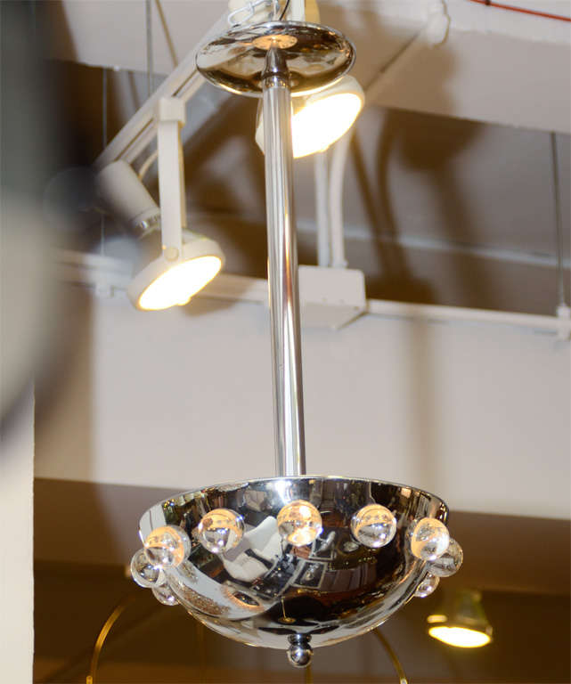 A vintage chandelier with a nickeled finish and twelve crystal ball details around the rim. The piece is by noted designer Jacques Adnet.