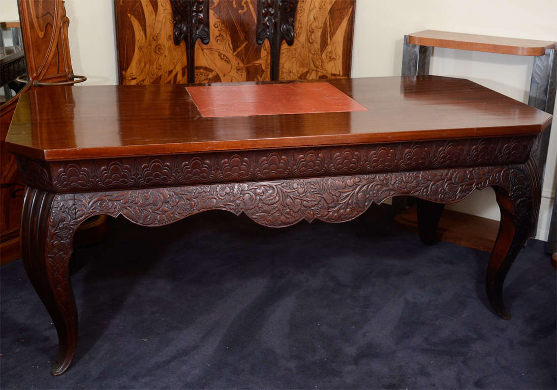 A vintage art deco period executive desk by Austrian designer Otto Prutscher. The piece has three drawers, hand carved floral detailing and a red leather inset writing surface. It is finished on all sides.
