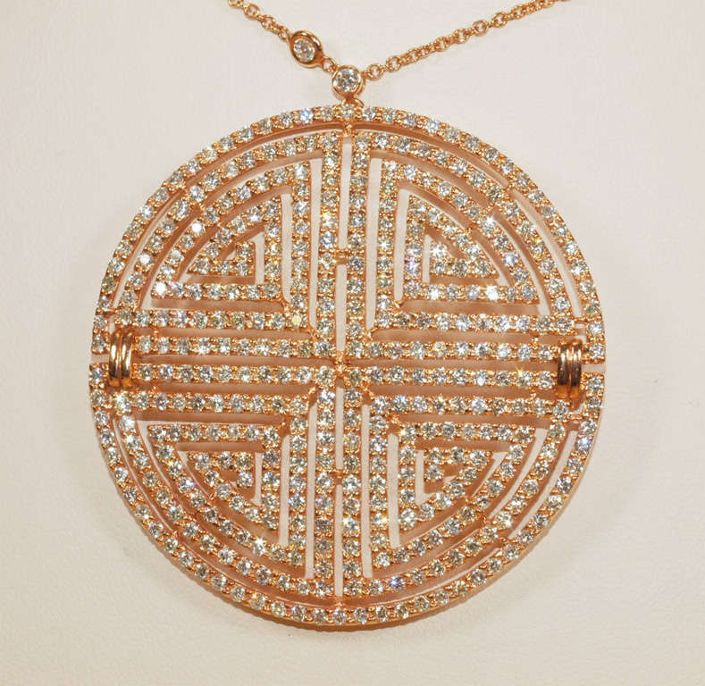 A classic Greek key labyrinth pendant set in 18K rose gold embellished with round brilliant cut diamonds. Accompanied by a rose gold chain segmented with round brilliant cut bezel set diamonds.