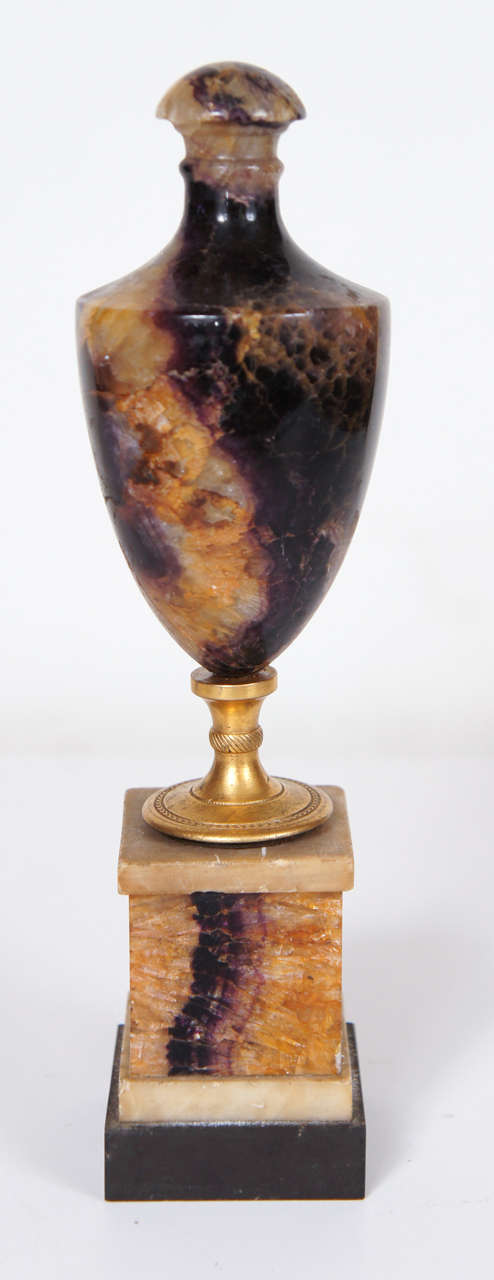 This  blue john urn and base are fine example of a rare and mined out stone found only in the Derbyshire region of England. Used to great advantage in the production of luxury goods in the very late 18th and into the early 19th century, this stone