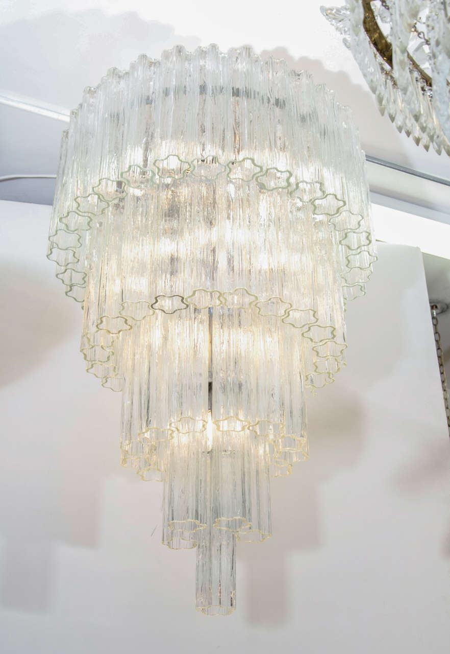 A vintage Italian chandelier by Venini composed of five-tiers of clear, tubular glass suspended from a chrome frame.