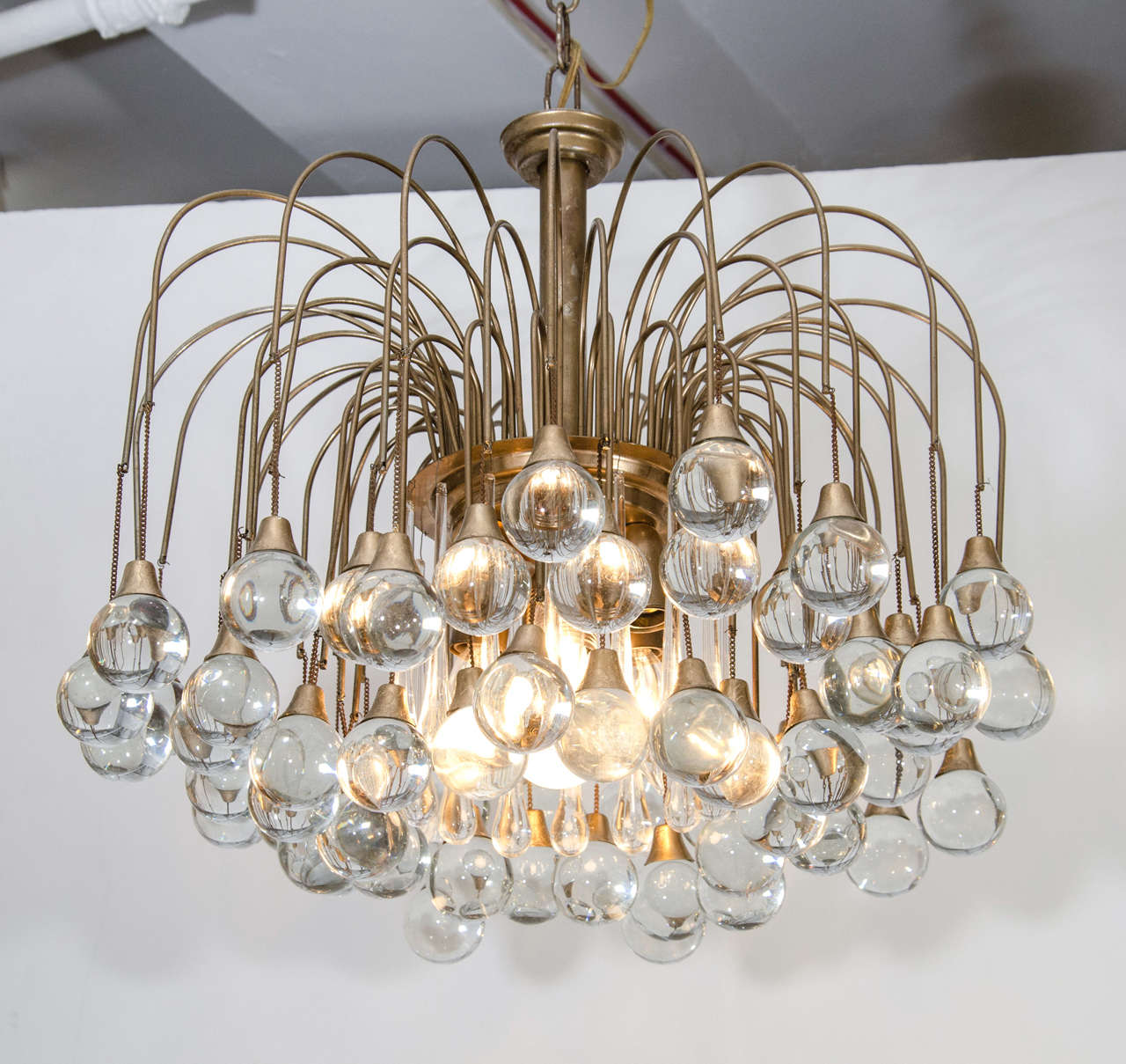 A vintage chandelier with clear glass drops hanging from brass arms.