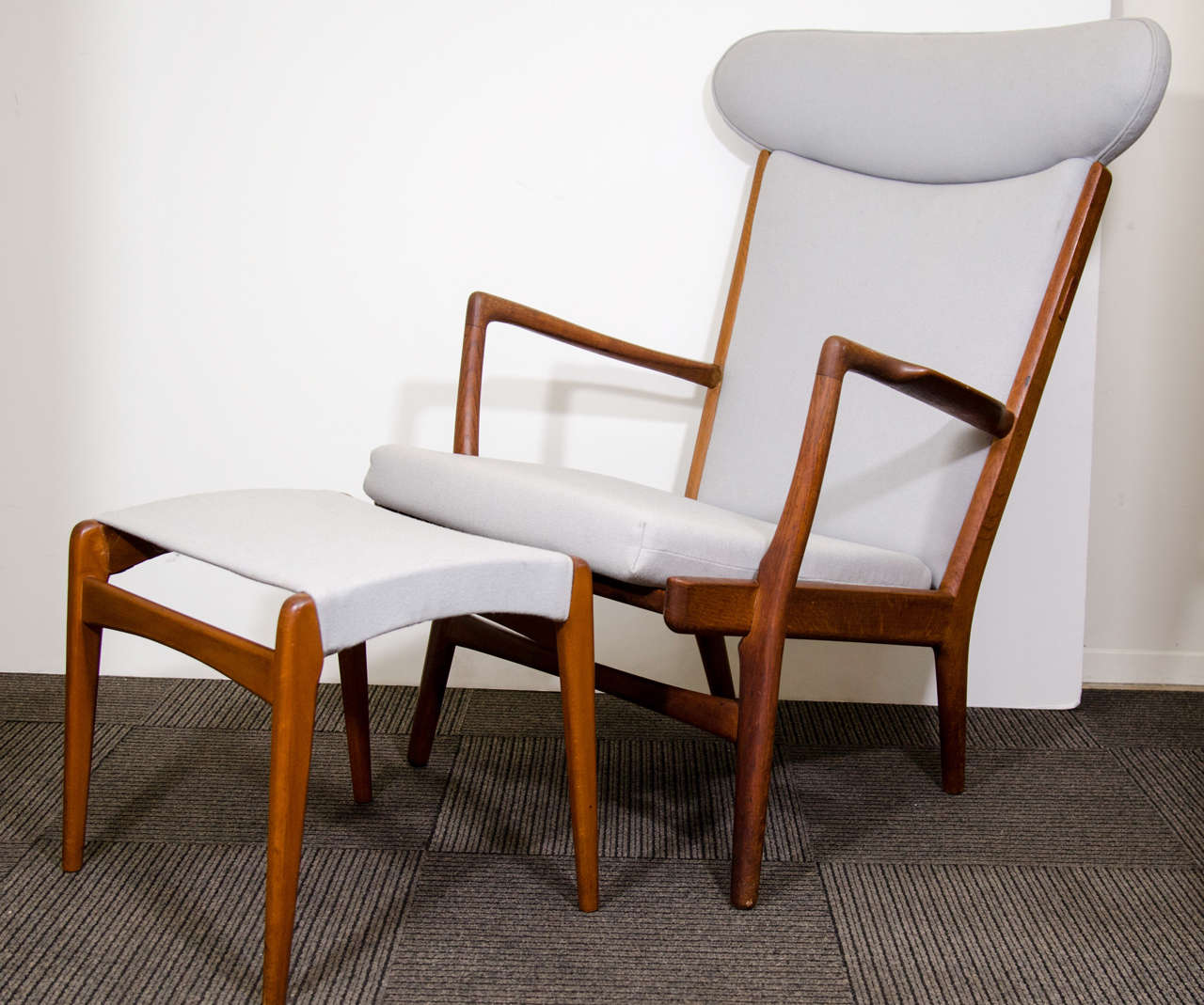 A vintage high back lounge chair by renowned Danish furniture designer Hans Wegner with matching teak ottoman by Fritz Hansen.

Chair
40" H x 30" W x 31" D x 18" S

Ottoman
17" H x 18" L x 15" W

6099