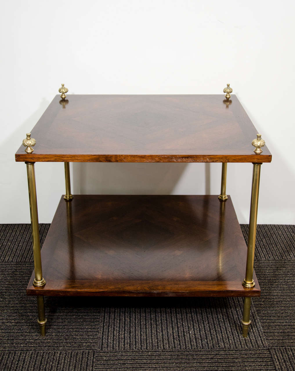 A vintage two-tier side table, produced circa 1960s, with rosewood tops, the exquisite natural patterns of the veneer creating a diamond shape, inset with classically formed brass legs. Very good vintage condition, with age appropriate wear.