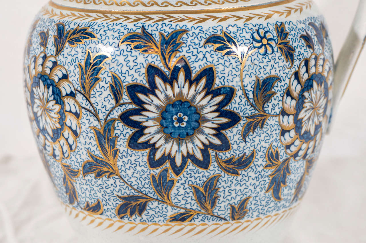 A blue and white pearlware jug with a lively design of flower buds presented as pinwheels and starbursts. An outstanding example of transfer printed pottery.