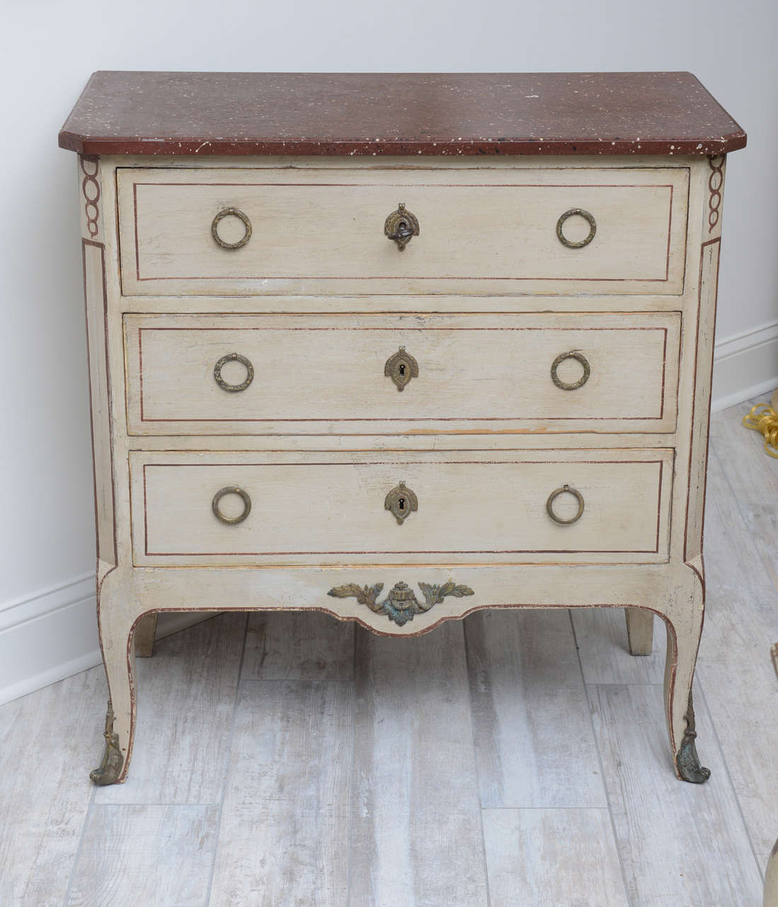 Handsome Louis XVI style painted chest with elegant hardware accents.