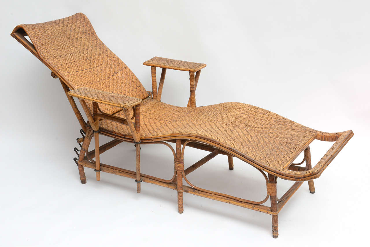 Fabulous French rattan lounge chair with adjustable back and removable right arm.