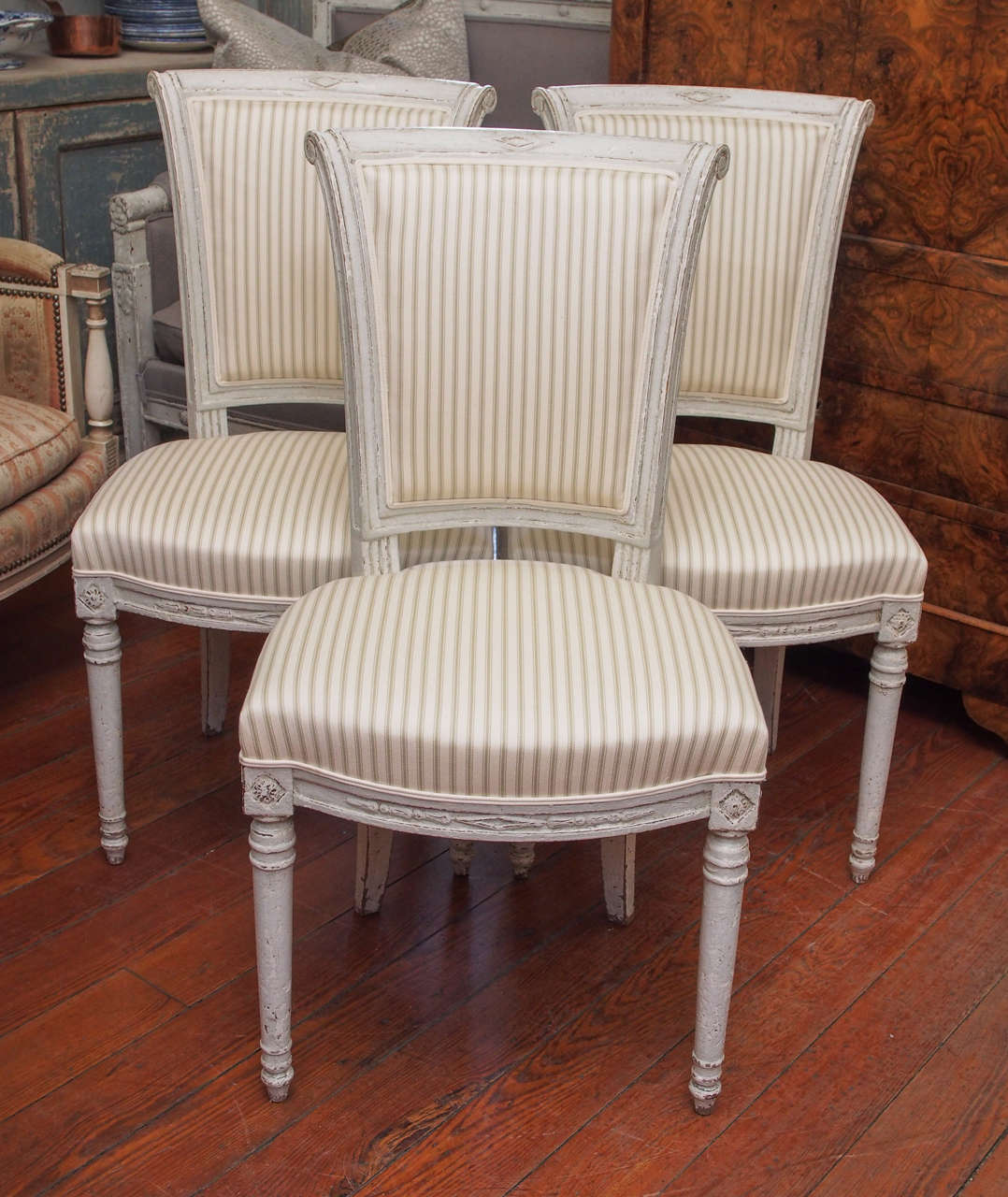 Late 19th century set of six dining room chairs with refreshed paint and newly upholstered in a cream/taupe stripe fabric. Directoire style.